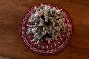 Flat lay of red knitted Christmas tree skirt with white Nordic snowflake and pine patterns