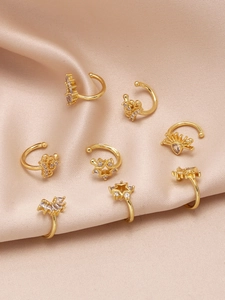 Lot de sept ear cuffs dorés avec cristaux sur tissu en satin champagne élégant
