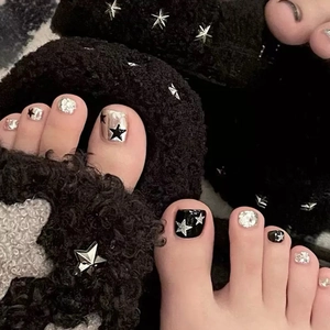 Sparkly black and silver star press-on toenails with glitter and rhinestone accents