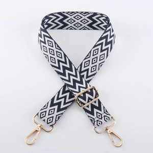 Nahaufnahme des geometrischen Jacquard-Schultergurts mit goldenen Karabinerhaken und Schnalle