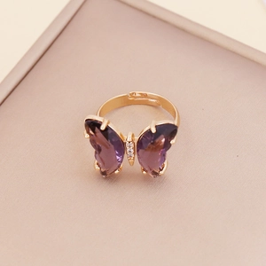 Macro view of adjustable butterfly ring with purple crystals and gold-plated finish