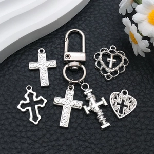 Detailed view of silver cross and heart pendants on a professional black textured background
