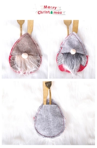 Close-up of festive gnome cutlery holders in red and grey felt with golden utensils
