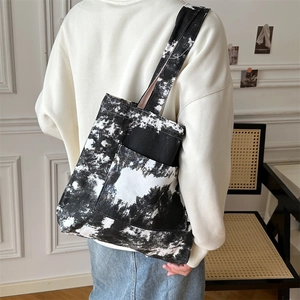 Borsa tote in tela tie-dye con grande tasca frontale indossata a tracolla elegante