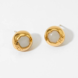 Detail of round vintage earrings with white shell inlay and hammered gold finish