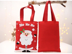 Close-up of festive red felt Christmas gift bags with Santa Claus and HO HO HO print