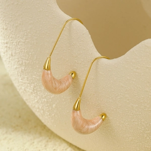 Detailed close-up of C-shaped pink marble resin drops on a golden earring hook