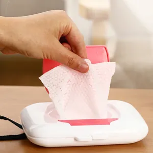 Portable wet wipe dispenser with white body and pink lid on a wooden surface