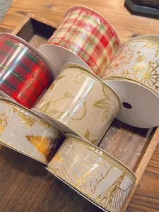 Close-up of assorted Christmas ribbons with gold snowflake and tree patterns on wood