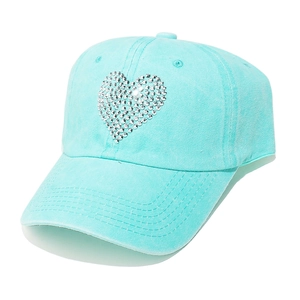 Detailed view of heart-shaped silver rhinestone motif on a light blue washed cotton cap