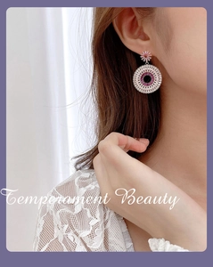 Close-up of a model wearing circular gradient zircon hoop earrings in pink and purple