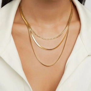 Three-layer 18k gold plated necklace featuring snake, figaro, and beaded chains on a model