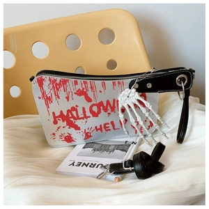 Close-up of clever meat cleaver handbag with red blood stains and skeletal hand charm