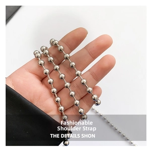 Detailed view of polished silver bead chain strap with glossy metallic finish for handbags
