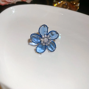 Macro shot of a blue crystal flower ear cuff with sparkling zircon and starburst light