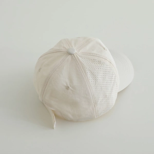 Close-up of cream quick-dry baseball cap featuring breathable laser-cut side perforations