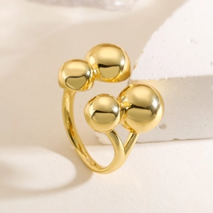Adjustable golden irregular geometric ring featuring four polished spheres on a white stone