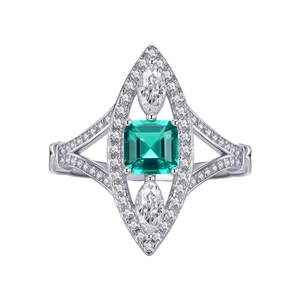 Macro shot of marquise emerald ring with pavé diamonds on textured silver band