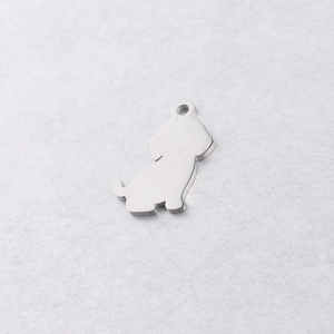 Macro shot of silver stainless steel puppy pendant with smooth polished finish for DIY