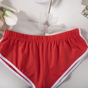 Detail von roten Sportshorts mit weißem Saum und elastischem Bund auf Texturhintergrund
