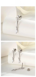 Macro detail of silver dagger earrings featuring marquise zircon and screw back closure