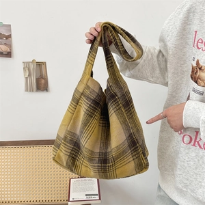Detail of tan plaid wool tote bag showing thick textured fabric and wide shoulder strap