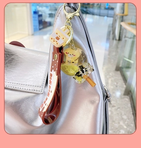 Detail of cartoon bear liquid keychain with glitter floating charm on a silver bag
