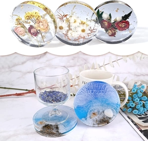 Macro view of crystal resin coaster with dried flowers, gold foil, and seashells