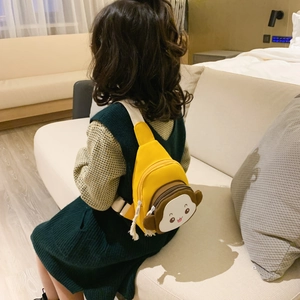 Cute yellow monkey shaped kids chest bag worn by a young girl on a sofa