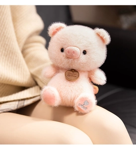 Detail of pink plush pig toy with soft fur texture and silver sequin embroidery on foot