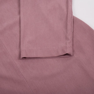 Macro detail of the fine-wale corduroy fabric and neat stitching on a mauve midi dress