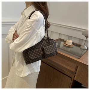 Detail view of retro brown shoulder bag with dual flap pockets and vintage pattern