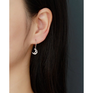 Close-up of s925 silver moon hoop earring with hollow star pattern on female model