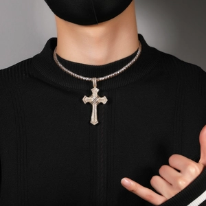 Close-up of gold cross pendant with pavé cubic zirconia on tennis chain worn by a model