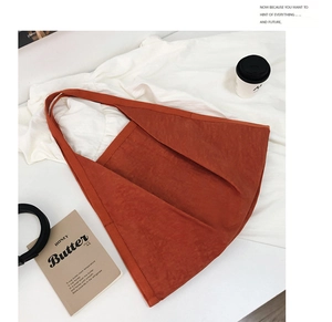 Flat lay of caramel corduroy tote bag with aesthetic props on white fabric