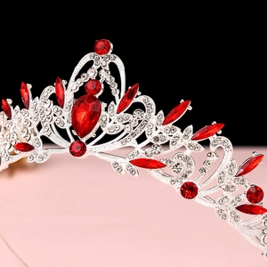 Macro shot of a baroque crown featuring red crystals and intricate silver filigree details