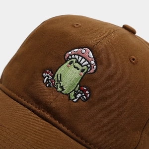 Close-up of cute frog mushroom embroidery on dark brown cotton twill baseball cap
