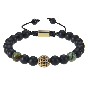 Macro detail of hand-woven beaded bracelet with matte black beads and gold zircon ball