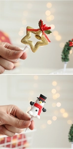 Detail of Christmas cake toppers featuring golden star and 3D snowman with festive bow