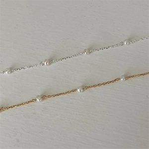 Detail of minimalist S925 sterling silver bracelets with freshwater pearls in gold and silver