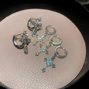 Close-up of sparkling rhinestone cross pendant hoop earrings in various colors and sizes