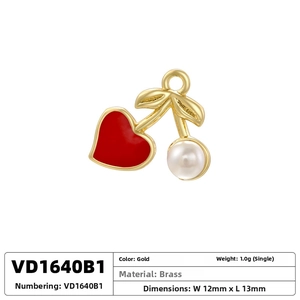 Detail of cherry pendant with red heart enamel and white pearl on brass gold plating