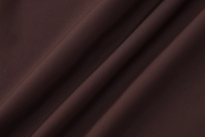 Macro shot of dark brown ribbed knit fabric showing soft texture and detailed stitching