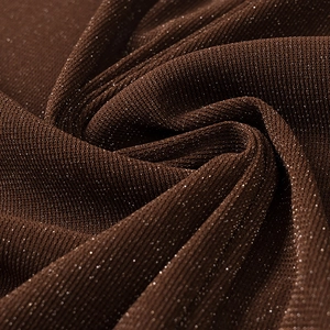 Detailed close-up of dark brown knit fabric with shimmering glitter and metallic texture