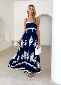 Detail of bohemian deep blue maxi dress with white embroidery and open back style