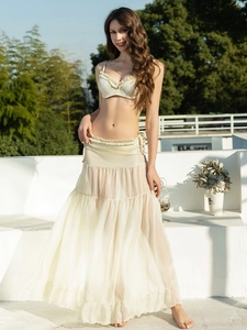 Detail of light beige bikini top with ruffle trim and sheer layered long sarong skirt