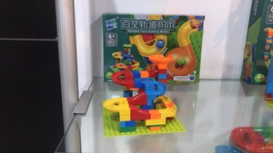 Detail view of colorful DIY marble run building block set with funnel pieces in box