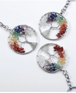 Detailed view of colorful natural crystal stones woven into a metal Tree of Life pendant