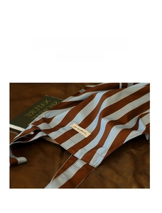 Detail view of durable apron fabric with premium leather logo tag and stripe pattern