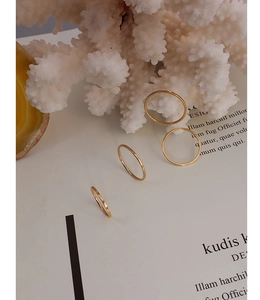 Minimalist 18k gold plated titanium rings displayed on an elegant aesthetic background